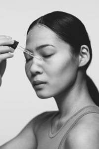skin woman serum on her skin black and white
